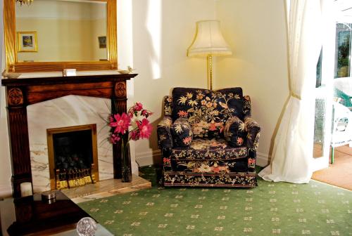 a living room with a chair and a fireplace at The Long Range in Budleigh Salterton