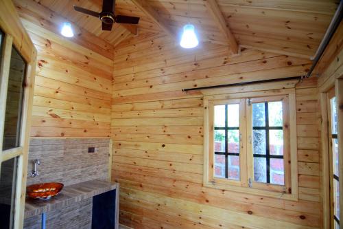 Cabaña de madera con baño con paredes de madera y ventana en Cozywoods Hill Resort en Banastarim