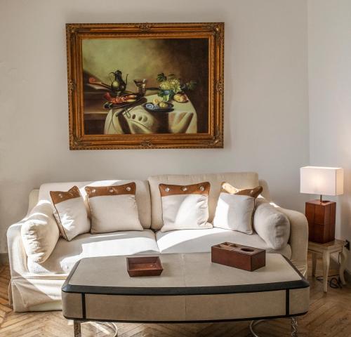 a living room with a couch and a painting on the wall at Château de Tressé in Pouancé