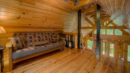 a living room with a couch in a wooden cabin at Row Harder in Blue Ridge