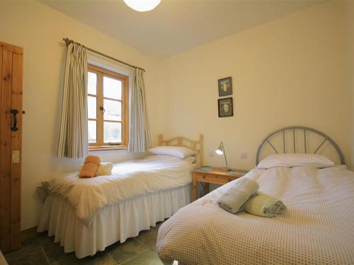 a bedroom with two beds and a window at Robbie's Barn in Halford