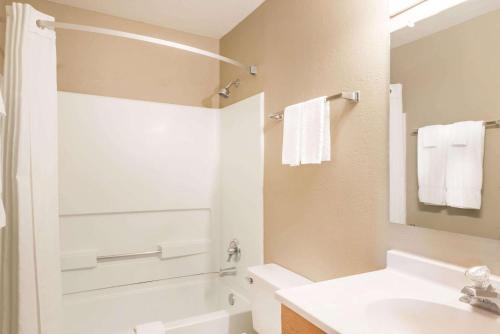 a bathroom with a white tub and a sink at Super 8 by Wyndham Socorro in Socorro