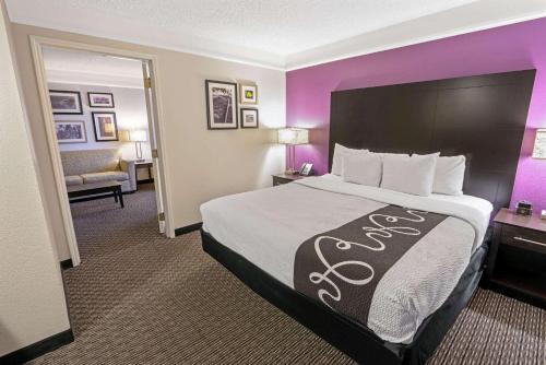 a hotel room with a large bed and purple walls at La Quinta by Wyndham Phoenix Scottsdale in Scottsdale