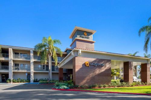 una vista frontal de un hotel con palmeras en La Quinta by Wyndham Orange County Airport, en Santa Ana