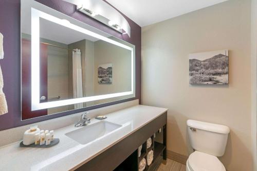 a bathroom with a sink and a toilet and a mirror at La Quinta by Wyndham Williams-Grand Canyon Area in Williams