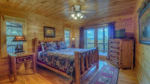 Un dormitorio con una cama en una cabaña de troncos en Sunset Lodge, en Blue Ridge