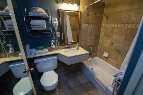 a bathroom with a sink and a toilet and a tub at Kachina Lodge - Inside the Park in Grand Canyon Village