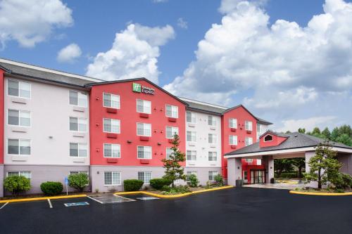 a hotel with red and white buildings in a parking lot at Holiday Inn Express & Suites Lincoln City by IHG in Lincoln City