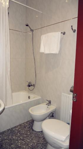 a bathroom with a toilet and a sink and a tub at Hostal el Volao in Villanueva de Córdoba