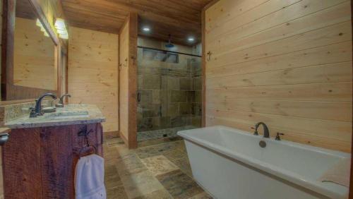 Un baño con bañera, lavabo y ducha. en Triple Vista Mountain Tops, en Blue Ridge