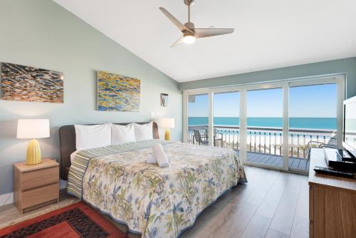 1 Schlafzimmer mit einem Bett und einem Balkon mit Meerblick in der Unterkunft Hidden Cove Unit 6 in Holmes Beach