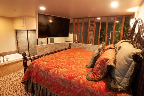 a bedroom with a large bed and a flat screen tv at Destinations Inn Theme Rooms in Idaho Falls