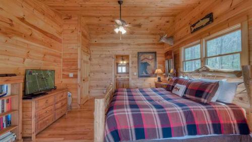 a log cabin bedroom with a bed and a tv at Wilderness Way in Blue Ridge