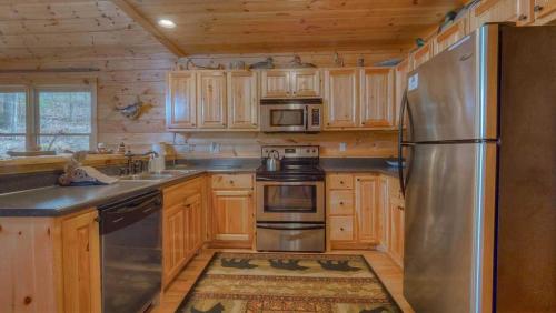 a kitchen with wooden cabinets and a stainless steel refrigerator at Wilderness Way in Blue Ridge