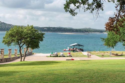 a group of people sitting in a park near the water at Comanche Trail Guest House in Volente