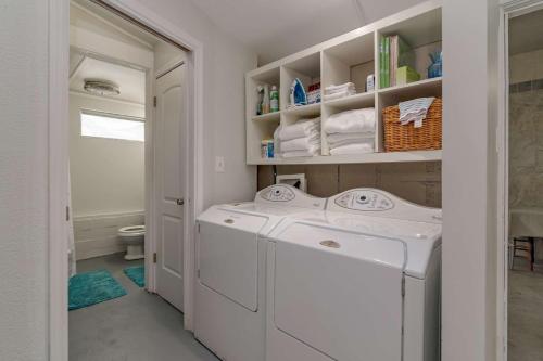 een witte wasruimte met een wasmachine en droger bij The Nest on Lake Travis in Buffalo Gap