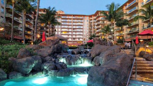 a resort pool with a waterfall in front of a hotel at Honua Kai - Hokulani 509 - Ocean view from INSIDE! 2b/2b in Kaanapali