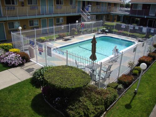 einen Pool mit einem weißen Zaun um ihn herum in der Unterkunft Oasis Inn Sacramento- Elk Grove in Sacramento
