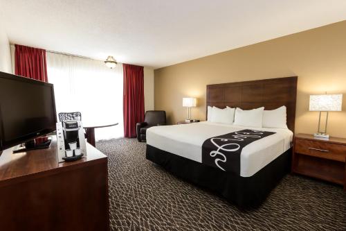 a hotel room with a bed and a flat screen tv at La Quinta by Wyndham Clearwater Central in Clearwater