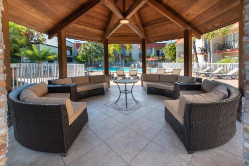 acovered patio with couches and a table and chairs at La Quinta by Wyndham Clearwater Central in Clearwater