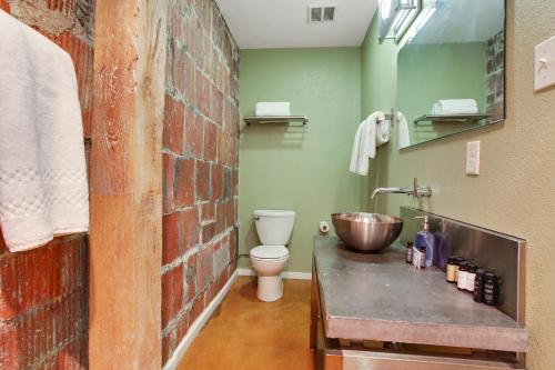 a bathroom with a sink and a brick wall at LiivUP Warehouse Apartments in New Orleans