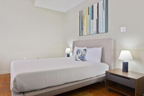 a bedroom with a white bed and a table at LiivUP Warehouse Apartments in New Orleans
