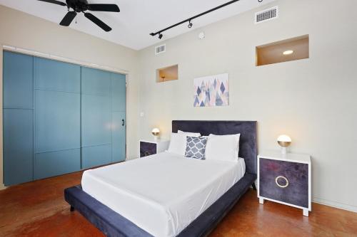 a bedroom with a white bed and a ceiling fan at LiivUP Warehouse Apartments in New Orleans