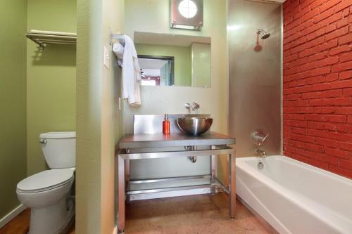 a bathroom with a sink and a toilet and a bath tub at LiivUP Warehouse Apartments in New Orleans