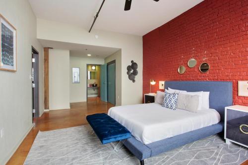 a bedroom with a large bed and a red brick wall at LiivUP Warehouse Apartments in New Orleans