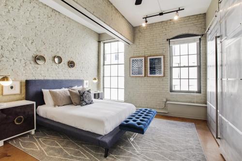 a bedroom with a bed and a brick wall at LiivUP Warehouse Apartments in New Orleans