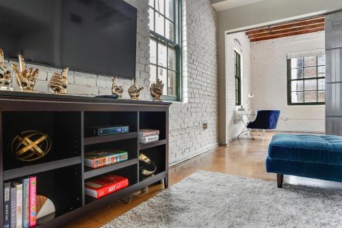 a living room with a tv on a wall at LiivUP Warehouse Apartments in New Orleans