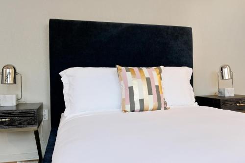 a bed with a black headboard and white pillows at LiivUP Warehouse Apartments in New Orleans