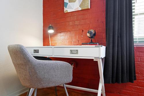 a desk with a chair next to a brick wall at LiivUP Warehouse Apartments in New Orleans