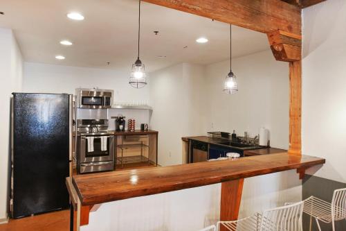 a kitchen with a black refrigerator in a room at LiivUP Warehouse Apartments in New Orleans