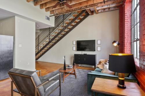 a living room with a couch and a tv at LiivUP Warehouse Apartments in New Orleans