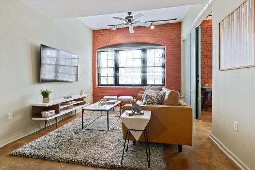 a living room with a couch and a brick wall at LiivUP Warehouse Apartments in New Orleans