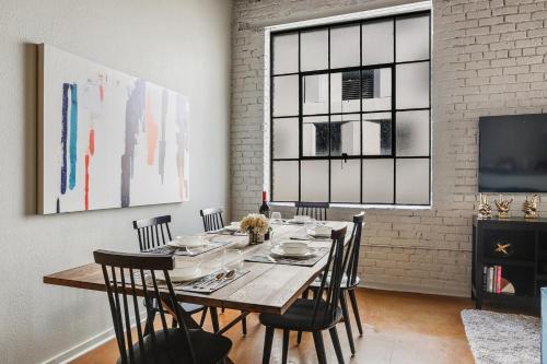 a dining room with a wooden table and chairs at LiivUP Warehouse Apartments in New Orleans