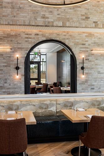 a restaurant with a mirror and tables and chairs at The Brownwood Hotel & Spa in The Villages