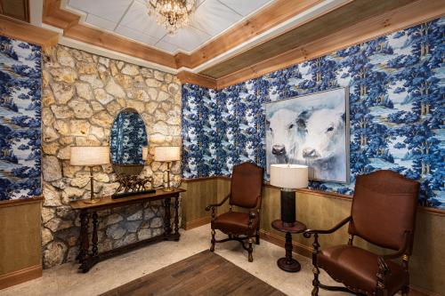 a room with blue floral wallpaper and two chairs at The Brownwood Hotel & Spa in The Villages