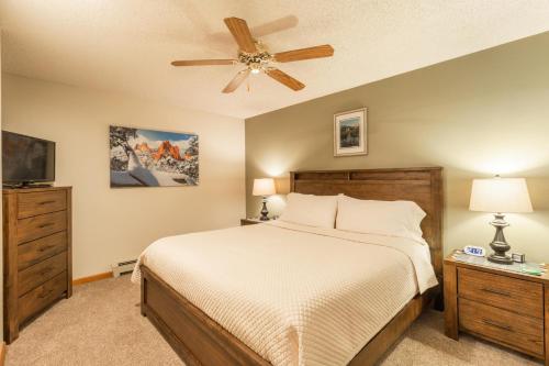 1 dormitorio con 1 cama y ventilador de techo en Woodlands on Fall River en Estes Park