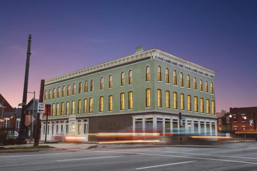 a green building on the corner of a street at Hancock House in Louisville