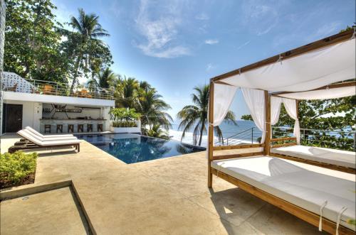an outdoor patio with a bed and a swimming pool at Garten Hotel in El Zonte