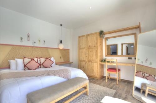 a bedroom with a bed and a desk with a chair at Garten Hotel in El Zonte