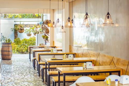 una fila de mesas y sillas en un restaurante en Greenview Medellin By St Hoteles, en Medellín