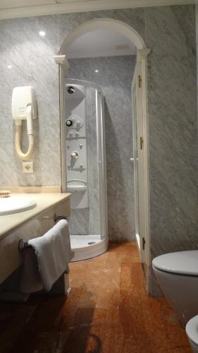 a bathroom with a sink and a toilet and a mirror at Hotel El Volao in Villanueva de Córdoba