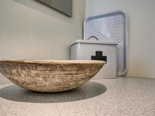 a wooden bowl sitting on a floor in a room at The Old Dairy in Burford