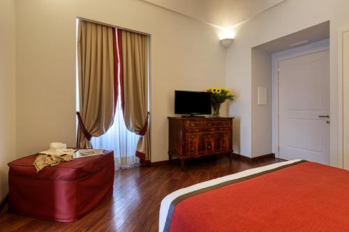 a bedroom with a bed and a television and a dresser at Decumani Hotel De Charme in Naples