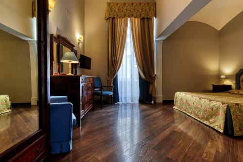 a bedroom with a bed and a dresser and a mirror at Decumani Hotel De Charme in Naples