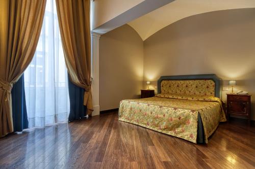 a bedroom with a bed and a large window at Decumani Hotel De Charme in Naples