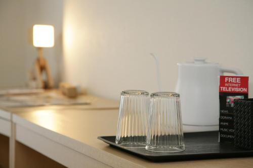 two empty glasses sitting on a tray on a counter at goom Hotel Fukuoka-Kokusai-Center in Fukuoka